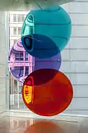 Three glass disks, with one coloured turquoise, another purple, and a third coloured red