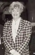 A picture of Elizabeth Connelly, an older woman smiling in a plaid suit.