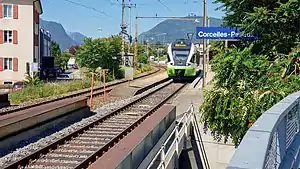 Green-and-white train on track between side and island platform