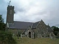 stone church with slate roof and slender tower