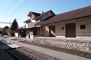 Two-story building with gabled roof and adjoining freight house