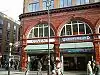 A red-bricked building with a white sign reading "COVENT" in blue letters and a blue sign reading "UNDERGROUND" in white letters under a white sky