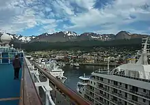 A city is seen from the deck of a docked cruise ship.