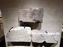 An image of symbols etched on three block of stones. alt= Phoenician writing from right to left.  First line reads: Mēm Lāmedh Kaph Bēth Dāleth ʼAyin Šin Tāw Rēš Tāw Nun Bēth Nun ṣādē Dāleth Qōph Yōdh Tāw Nun Mēm Lāmedh Kaph Mēm Lāmedh Kaph ṣādē Dāleth Nun Mēm. Second line reads: Bēth Nun Bēth Nun Mēm Lāmedh Kaph ʼĀleph Šin Mēm Nun ʼAyin Zayin Rēš Mēm Lāmedh Kaph ṣādē Dāleth Nun Mēm ʼĀleph Yōdh Tāw Hē Bēth Tāw Zayin. Third line reads: Bēth Nun Lāmedh ʼĀleph Lāmedh Yōdh Lāmedh ʼĀleph Šin Mēm Nun Šin Rēš Qōph Dāleth Šin