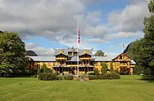 Large half-timbered building with sprawling wings, and an oriental-looking structure on the roof.