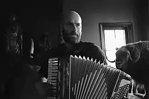 Romer playing the accordion in his studio