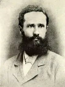 photograph of black-haired, bearded man