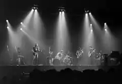 A black and white photo of four men performing onstage.