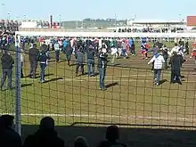 People in everyday clothing on football pitch