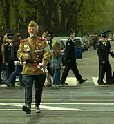 A man dressed as a veteran of the Great Patriotic War wearing both a gymnastyorka and a pilotka