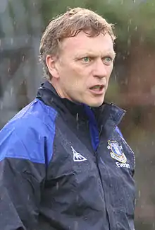 The head of a red-haired gentleman in his 40s. He is wearing a blue and white shirt.