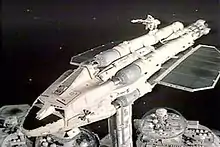 The image shows a futuristic spaceship docked with a structure representing part of a space station.