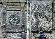 Two stone coats of arms, heavily worn from the weather.