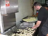 A baker deep-fries sufganiyot at the Mahane Yehuda Market, Jerusalem