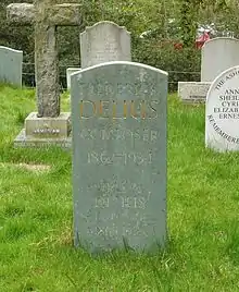 A slate headstone in a grassy churchyard