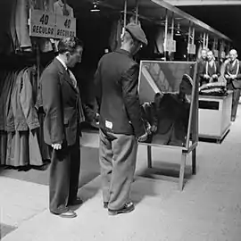 Private Bill Krepper of the Pioneer Corps is assisted in the selection of his demob suit.