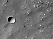 Recent small crater on floor of Dennin Crater, as seen by HiRISE.  Arrow shows group of secondary craters from ejecta falling down.