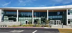 A colonnade with glass doors and a sign for Design Tech High School