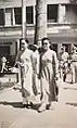 Two women wearing áo dài walking in Saigon, 1947.