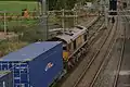 Diesel-hauled freight under the 25 kV wires on the West Coast Main Line at Cow Roast footbridge, near Tring