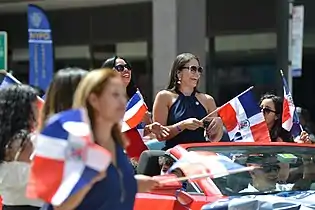 Dominicans in New York Dominican parade holding flags.