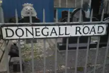 "Donegall Road" street sign attached to metal railings.