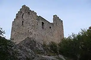 Stone building without roof. The right-hand side of the building has a triangular apex which suggests a gable roof.