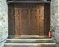 The doors beneath the tower are made from salvaged Tudor bench ends