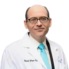 Photograph of Michael Greger in a white coat and brightly colored tie with a transparent background