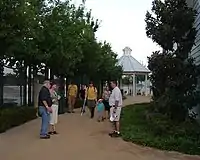 People visiting the ballpark walking along a tree-lined pathway