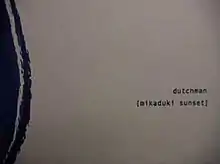 The words "Dutchman" and "Mikaduki Sunset" written on a white background with blue font, with a rough blue circle on the left side