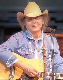 Country music singer Dwight Yoakam, singing while strumming a guitar