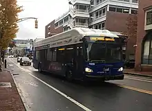 A dark blue bus operating on an urban street