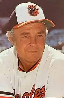 A man in a white baseball jersey and cap