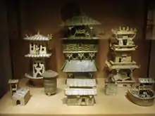 Among a large set of architectural models, three Eastern Han Dynasty watchtowers stand in the rear of this display.