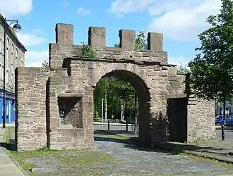 a colour photograph of an old gate in a portion of a town wall