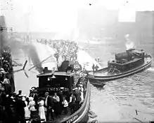 Passengers being rescued from the hull of the Eastland by a tugboat.