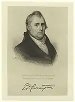 Print shows an unsmiling man in a dark coat with a white shirt. His signature is below.