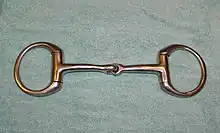 A metal horse bit with a jointed mouthpiece and a ring on either side