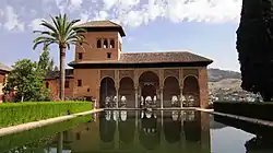 A Moorish style palace with a pool and a garden.