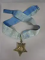 Star-shaped medal on a blue neck ribbon