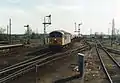 A class 56 heads a northbound aggregates train through Ely station. Note the semaphore signals which were removed during the electrification and resignalling scheme.