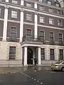 A policeman outside the embassy; the National Emblem of the People's Republic of China can be seen above the door