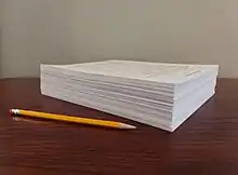 Photograph of 500 sheets of paper in a stack as an example 1,000 page turn report.