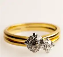 An engagement ring made in 18 karat yellow gold and platinum, set with two round old European-cut diamonds of 1.0cts and 0.30cts, marked Galt