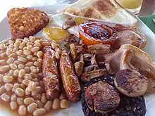 Image 58The full breakfast is among the best known British dishes, consisting of fried egg, sausage, bacon, mushrooms, baked beans, toast, fried tomatoes, and sometimes white or black pudding. (from Culture of the United Kingdom)