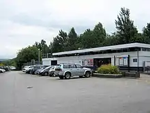 A low flat-roofed building with cars parked outside