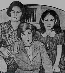 Photograph of two somber-faced young girls on either side of their mother