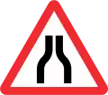 Road narrows on both sides