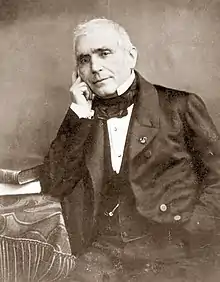  Photograph of middle aged white man in 19th century clothes; he is clean shaven apart from short side whiskers; his hair is short and white